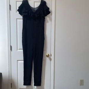 1X black ruffled jumpsuit with zipper in back and front pockets!